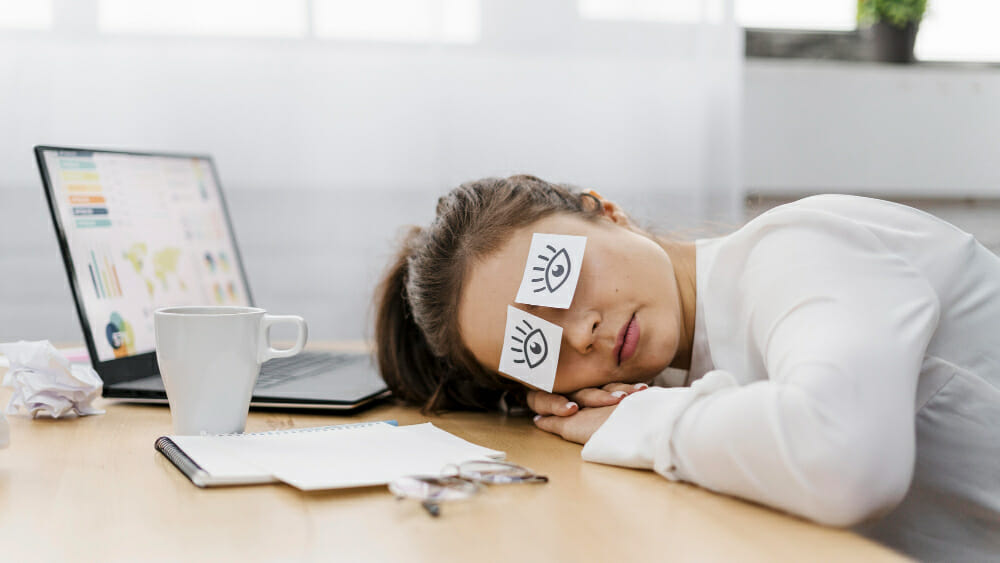 tired-businesswoman-covering-her-eyes-with-drawn-eyes-paper